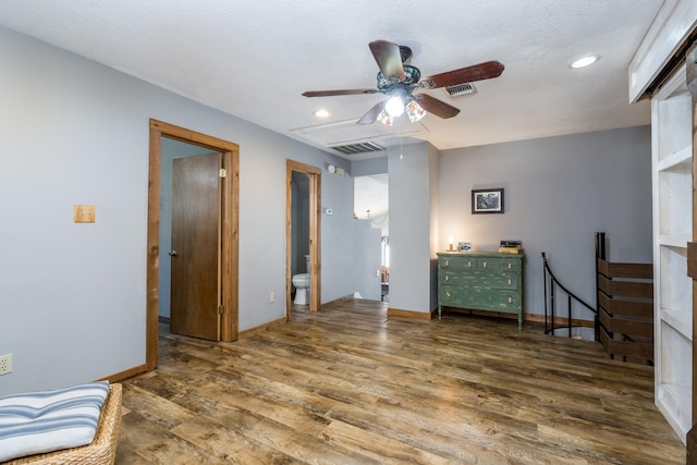 bedroom featuring ceiling fan, dark hardwood / wood-style floors, and ensuite bath