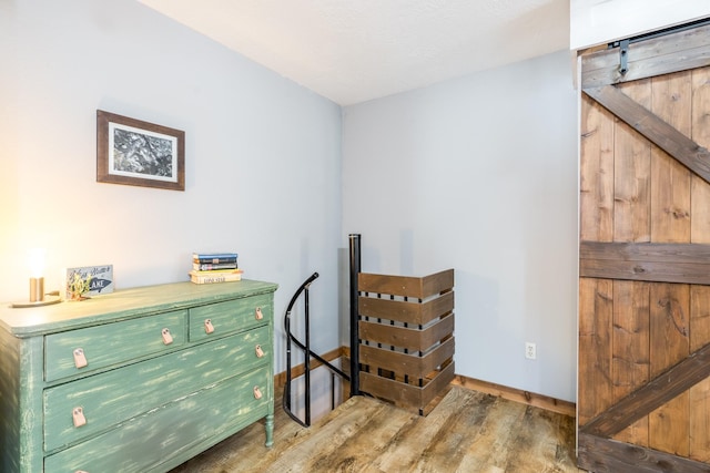 sitting room with wood-type flooring and a barn door