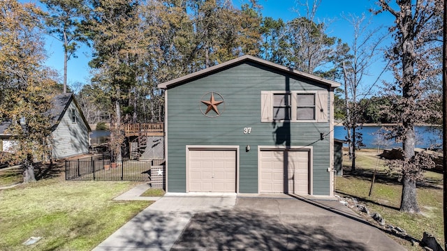 view of home's exterior featuring a garage, a deck with water view, and a yard