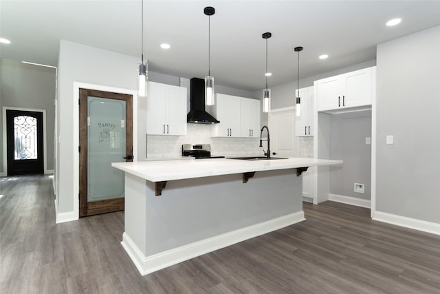 kitchen with sink, wall chimney range hood, a kitchen island with sink, and stainless steel electric range