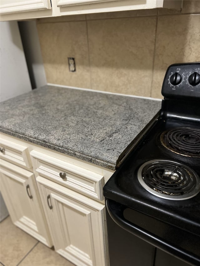 interior details featuring cream cabinets and black electric range