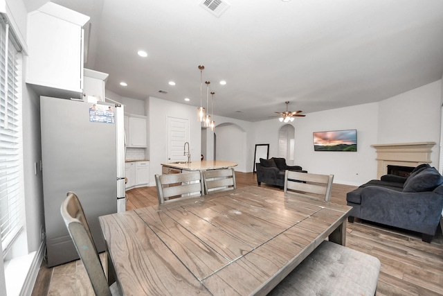 dining space featuring ceiling fan, sink, and light hardwood / wood-style floors