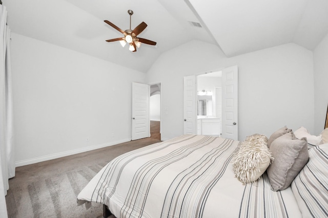 carpeted bedroom featuring lofted ceiling, ensuite bath, and ceiling fan