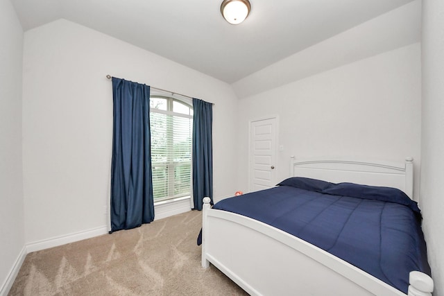 carpeted bedroom with lofted ceiling