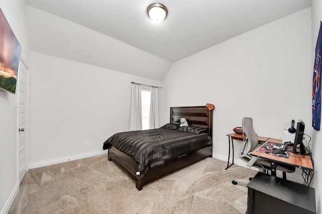 bedroom with vaulted ceiling and light colored carpet