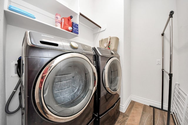 washroom featuring laundry area, independent washer and dryer, wood finished floors, and baseboards