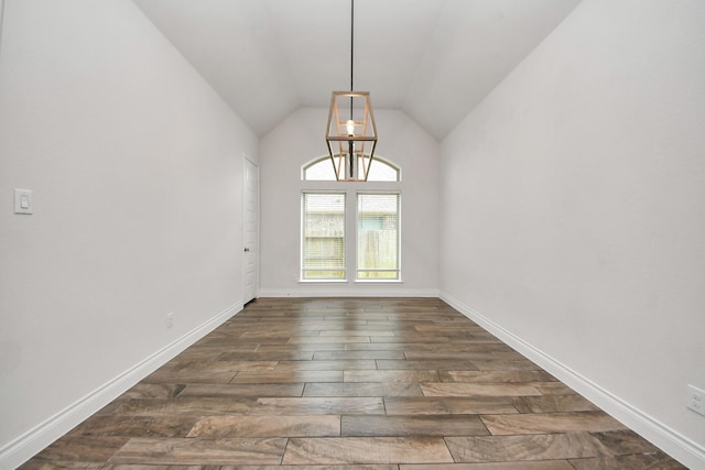 unfurnished room with baseboards, vaulted ceiling, and dark wood-type flooring