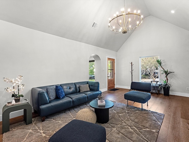 living room featuring an inviting chandelier, dark wood-type flooring, and high vaulted ceiling