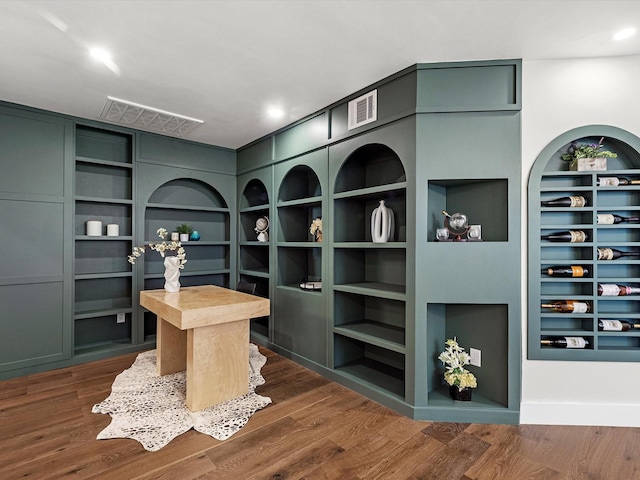 home office with dark hardwood / wood-style floors and built in shelves