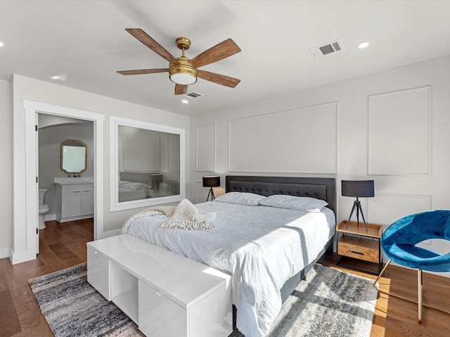 bedroom with hardwood / wood-style floors, ensuite bath, and ceiling fan