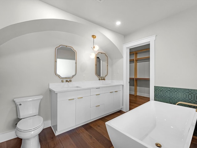 bathroom featuring vanity, a bathtub, toilet, and hardwood / wood-style flooring