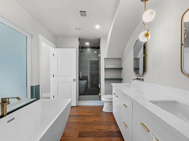 full bathroom featuring hardwood / wood-style flooring, vanity, toilet, and separate shower and tub