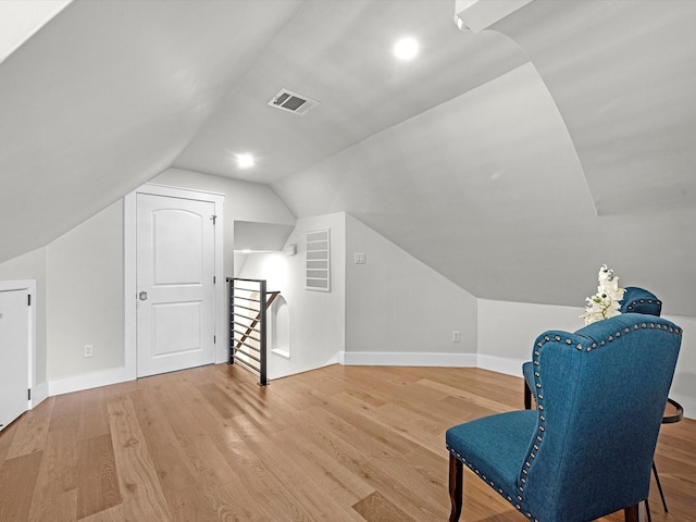 living area with hardwood / wood-style flooring and vaulted ceiling