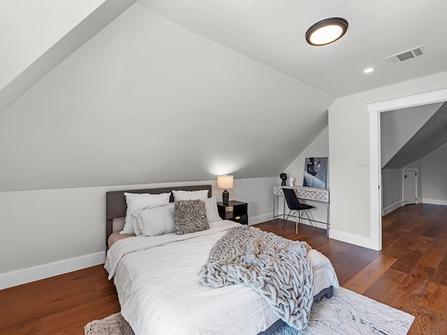 bedroom with vaulted ceiling and dark wood-type flooring