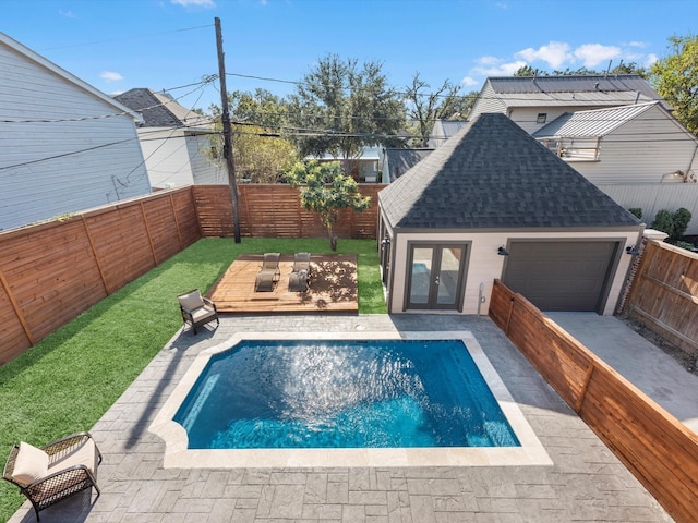 view of pool featuring french doors, a yard, and an outbuilding