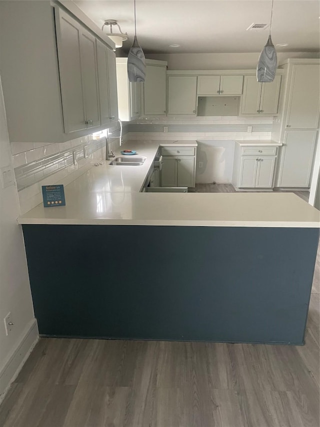 kitchen with sink, decorative light fixtures, and dark wood-type flooring