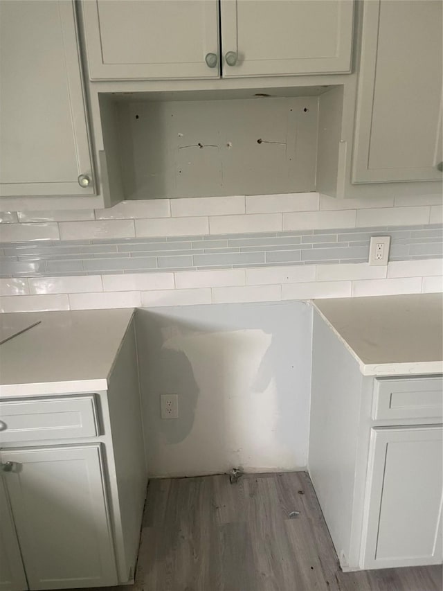 kitchen with tasteful backsplash and hardwood / wood-style flooring