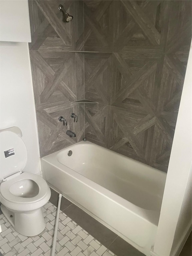 bathroom with tile patterned flooring, shower / bath combination, and toilet