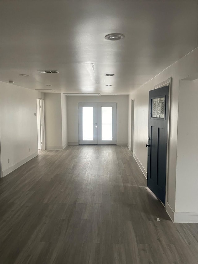 empty room with dark hardwood / wood-style flooring and french doors