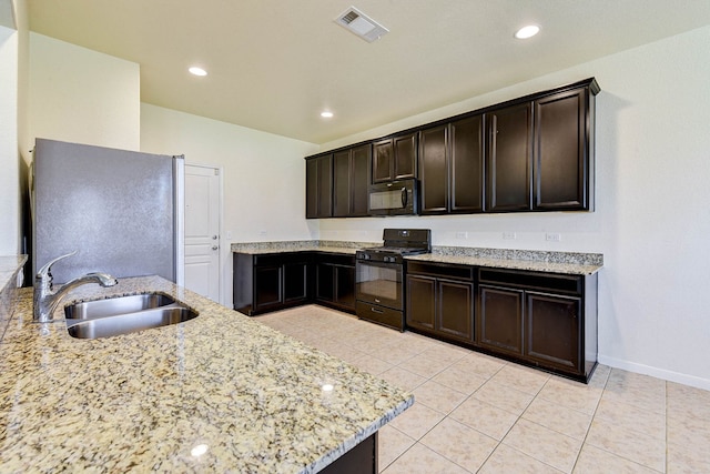 kitchen with light tile patterned flooring, dark brown cabinetry, sink, light stone countertops, and black appliances