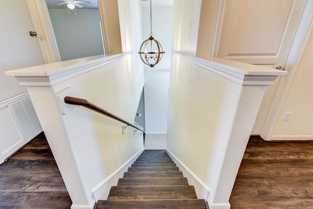 stairs featuring ceiling fan with notable chandelier and hardwood / wood-style floors