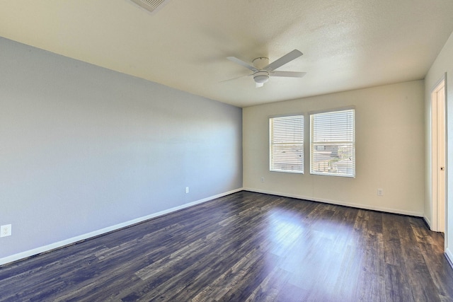 empty room with ceiling fan and dark hardwood / wood-style flooring