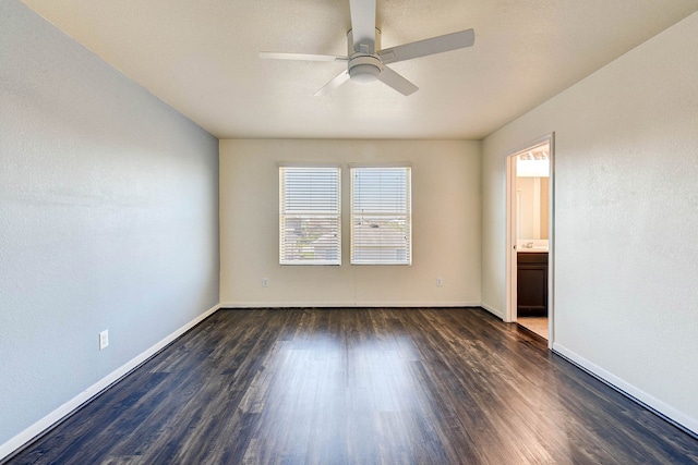 spare room featuring dark wood-type flooring and ceiling fan