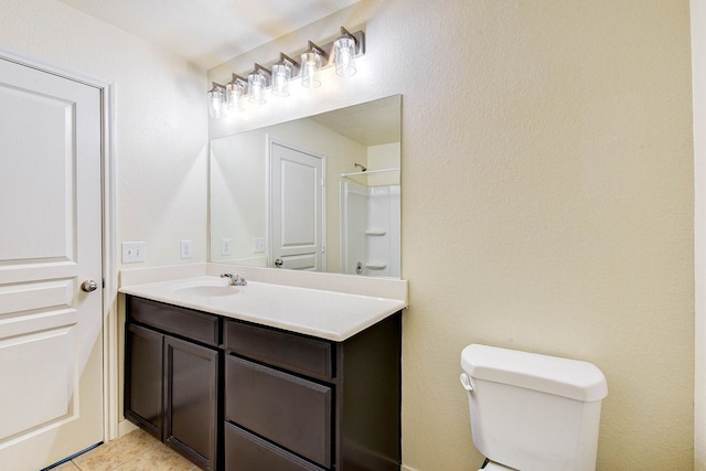 bathroom featuring vanity, toilet, tile patterned flooring, and a shower