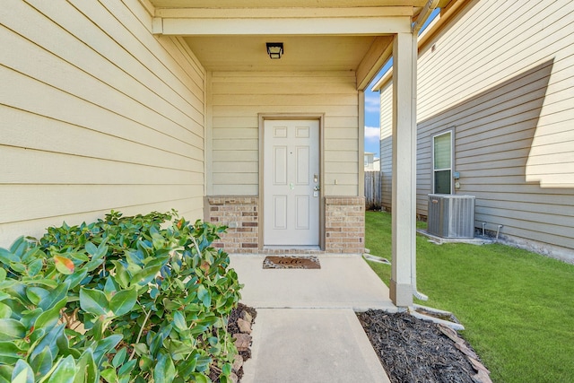 property entrance featuring central AC unit and a lawn