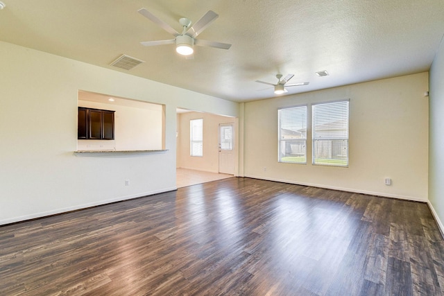 unfurnished living room featuring dark hardwood / wood-style flooring, a textured ceiling, and ceiling fan