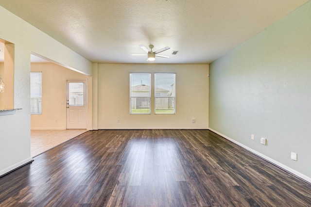 unfurnished room featuring ceiling fan, dark hardwood / wood-style floors, and a textured ceiling