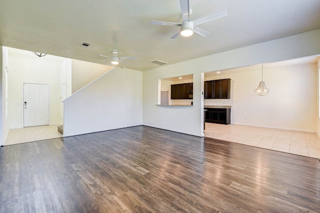 unfurnished living room featuring ceiling fan and hardwood / wood-style floors