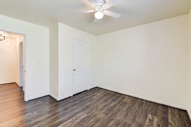 spare room with dark hardwood / wood-style flooring and ceiling fan