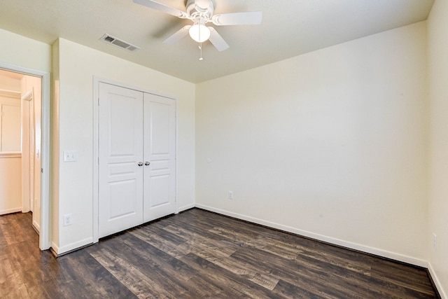 unfurnished bedroom featuring dark hardwood / wood-style flooring, a closet, and ceiling fan