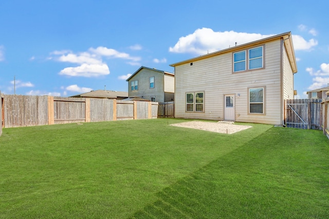 rear view of house featuring a yard and a patio area