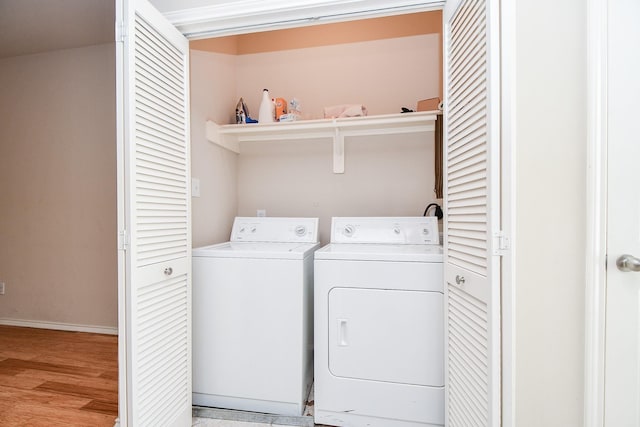 clothes washing area with separate washer and dryer and light hardwood / wood-style floors