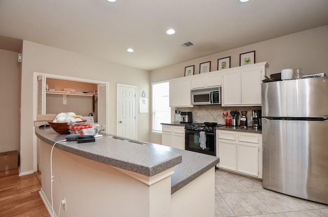 kitchen with white cabinetry, tasteful backsplash, stainless steel appliances, and a center island