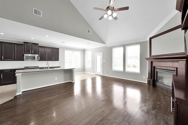 unfurnished living room with hardwood / wood-style flooring, ornamental molding, high vaulted ceiling, and ceiling fan