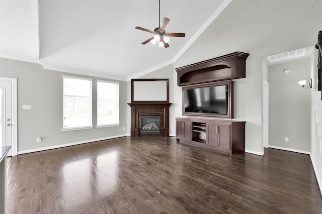 unfurnished living room featuring lofted ceiling, ceiling fan, dark hardwood / wood-style floors, ornamental molding, and a tiled fireplace