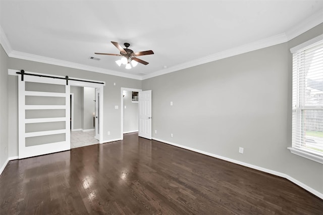 unfurnished bedroom with crown molding, a barn door, ceiling fan, and hardwood / wood-style flooring