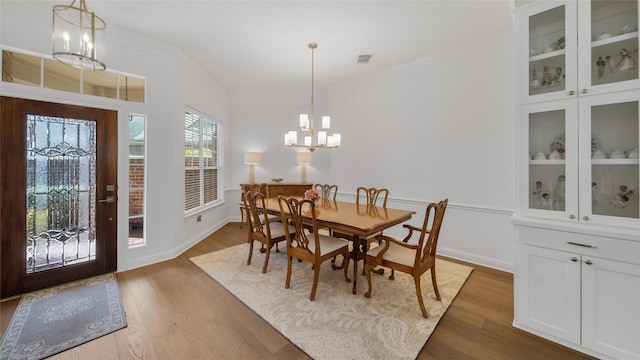 dining space with an inviting chandelier, dark hardwood / wood-style flooring, and crown molding