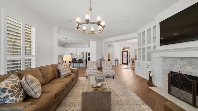 living room with hardwood / wood-style floors, crown molding, and a chandelier