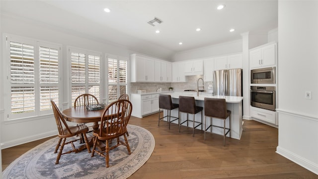 dining space featuring crown molding, sink, and dark hardwood / wood-style flooring