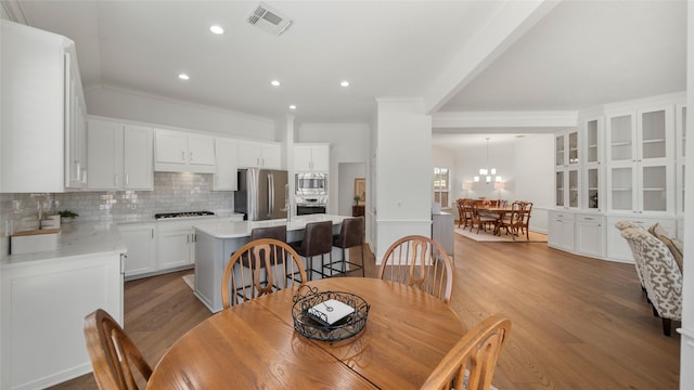 dining space featuring ornamental molding and light wood-type flooring