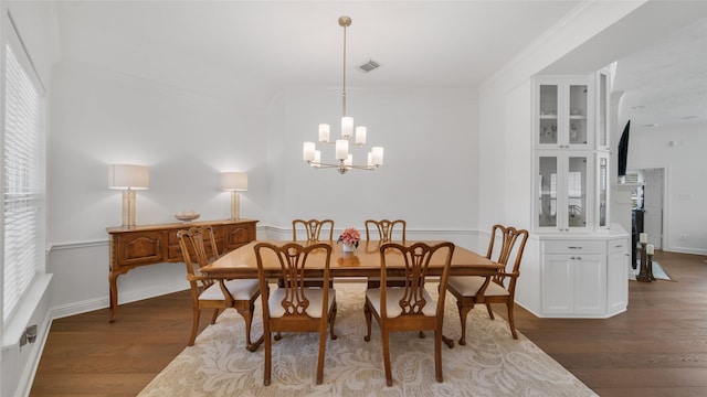 dining room featuring a notable chandelier, crown molding, and dark hardwood / wood-style floors