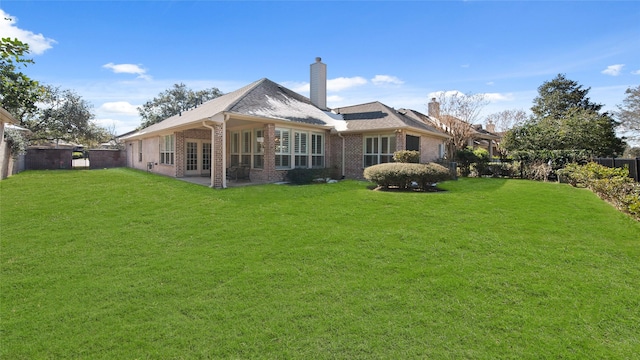 rear view of house with a yard and a patio area