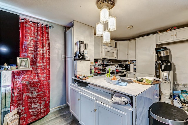 kitchen featuring decorative light fixtures, gray cabinetry, and wood-type flooring