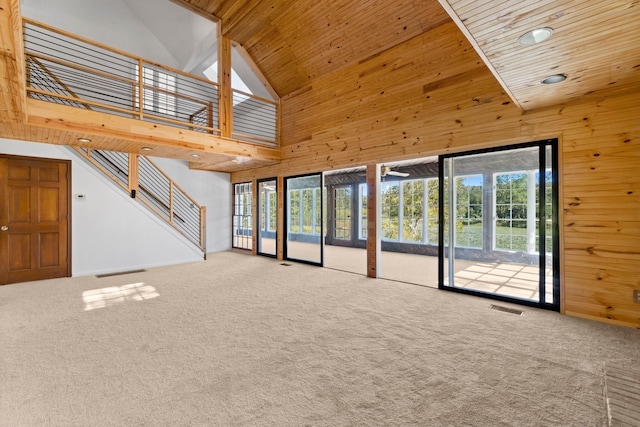 unfurnished living room featuring wood ceiling, high vaulted ceiling, and carpet