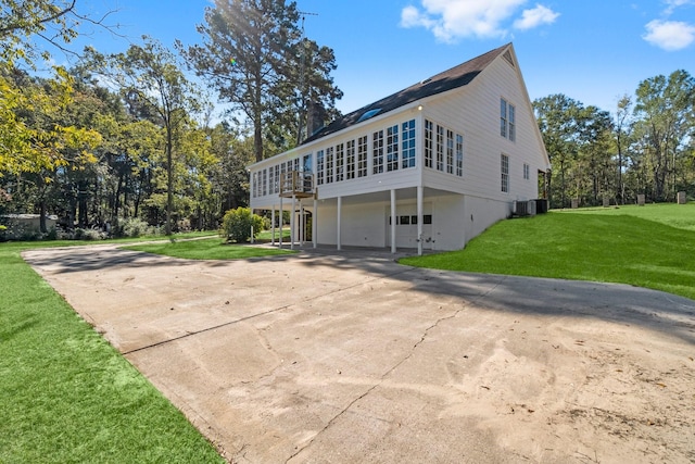 view of side of home with central AC, a garage, and a yard