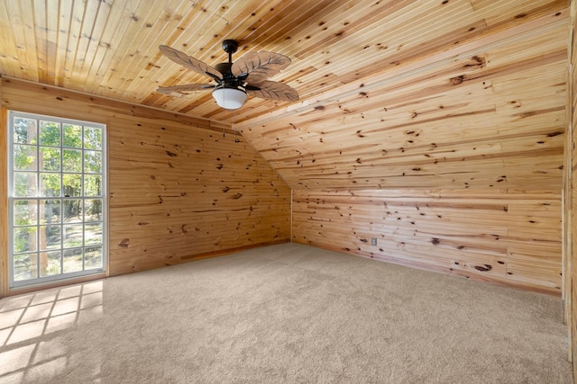 bonus room with vaulted ceiling, wooden ceiling, wooden walls, ceiling fan, and carpet